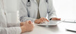 © rogerphoto - Doctor and patient sitting at the desk in clinic office. The focus is on female physician's hands using tablet computer, close up. Perfect medical service and medicine concept