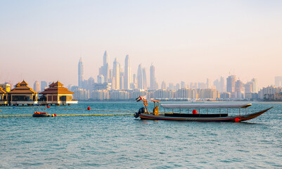 Sticker - Dubai, UAE. Tourists boat at Palm Jumeirah and Dubai marina at the background at sunset