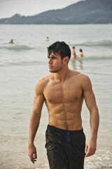 Wall Mural - Handsome young man standing on a beach in Phuket Island, Thailand