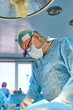 © Alexander Lupin - surgeon in the operating room is standing at the table with the patient under the lamp