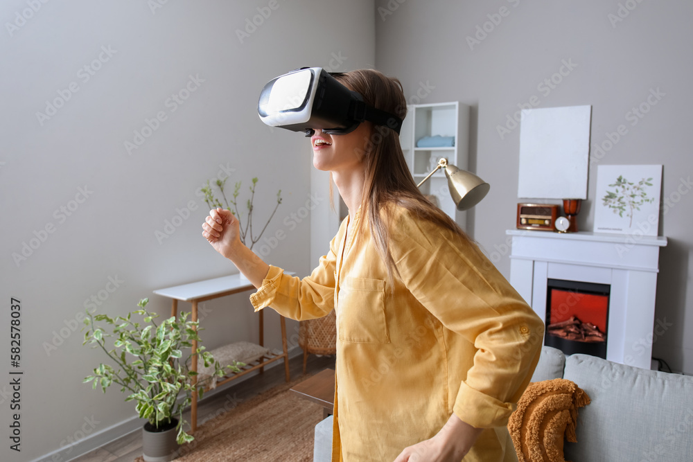 Pretty young woman in VR glasses at home