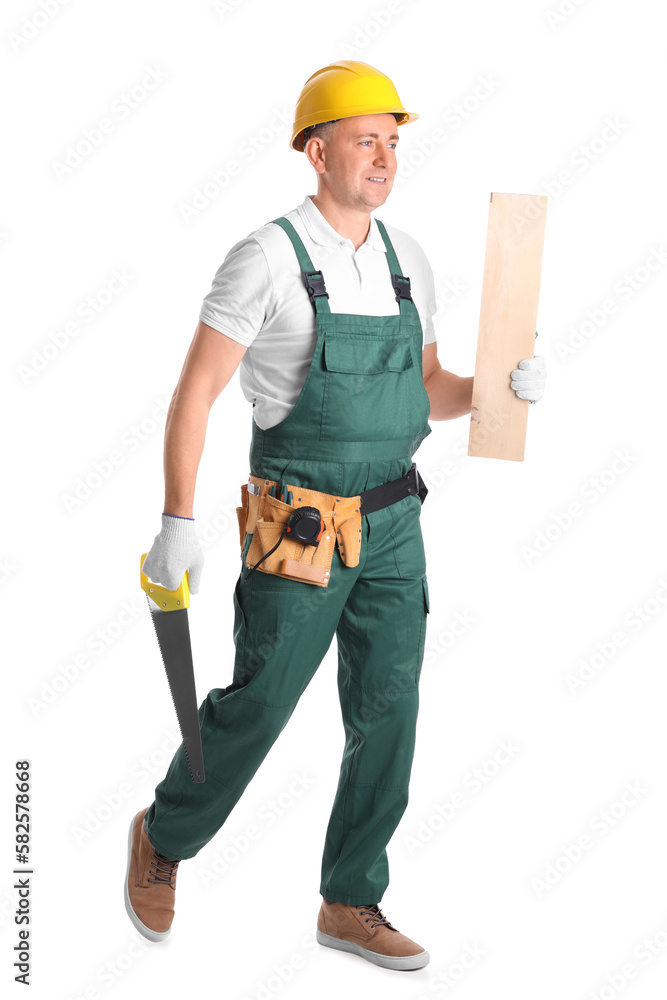 Mature carpenter with hacksaw and wooden plank on white background