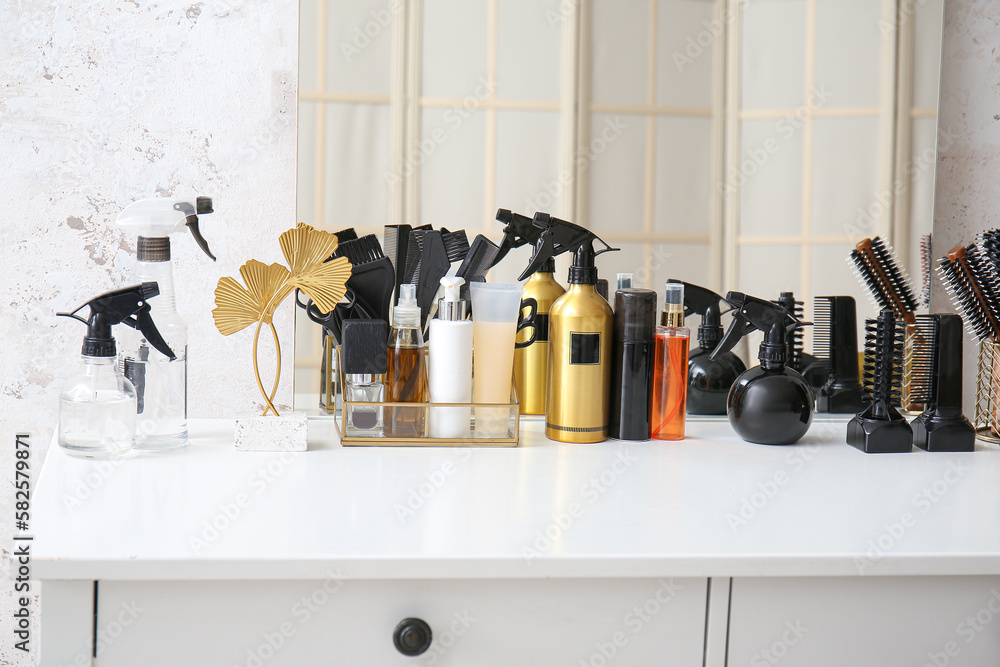 Hair sprays with accessories on table in beauty salon