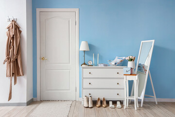 Interior of stylish hall with drawers and mirror