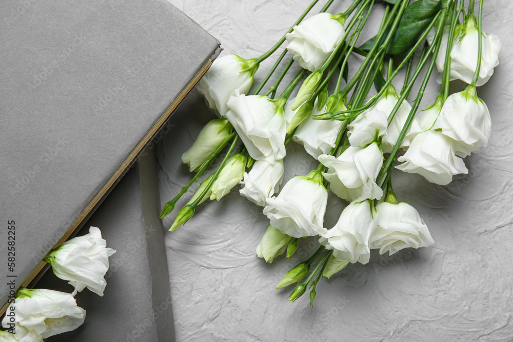 Beautiful eustoma flowers and books on light background, closeup