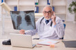 © Elnur - Old male doctor radiologist working in the clinic