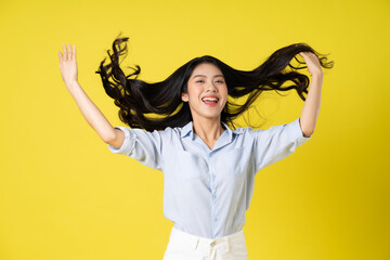 portrait of beautiful asian girl posing on yellow background