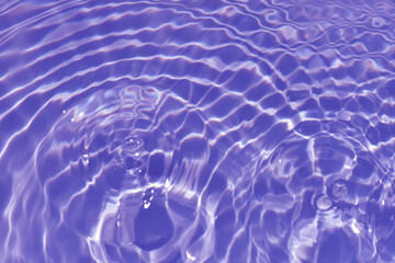 Wall Mural - Defocus blurred transparent purple colored clear calm water surface texture with splash, bubble. Shining purple water ripple background. Surface of water in swimming pool. Tropical purple water color.