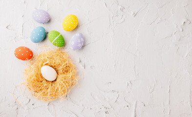 Wall Mural - Happy Easter Day Concept. Flat lay of holiday banner background web design easter eggs in brown nest on white cement background with empty copy space, celebration greeting card, overhead, template