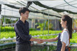 © NanSan - Shaking hands, Young asian farmer in celery and green oak salad hydroponic farm, smart farmer, freelancer with smes concept.