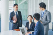 © HML - オフィスでミーティングをするビジネスマンの男女