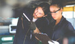 © NVB Stocker - Hispanic Female trainee Mechanics Working Underneath Car Together Car maintenance and auto service garage. Car maintenance and auto service garage concept.