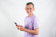 © Tyas Indayanti - Portrait of Asian Man wearing purple tshirt looks happy with the phone.