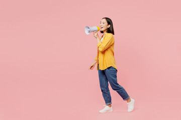 Wall Mural - Full body young woman of Asian ethnicity wear yellow shirt white t-shirt hold megaphone scream announces discounts sale Hurry up going isolated on plain pastel light pink background studio portrait.