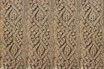 Wall Mural - Beige background knitted fabric with a pattern. Knitted Arans close-up