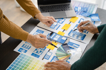 ui designer brainstorming about mobile app interface wireframe design with customer breif and color code at office.