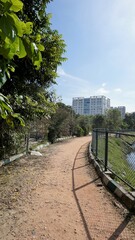 Wall Mural - Walking lane of iblur lake with green cover and clear cloudy skyn and cityscape infrastructure.