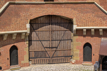 Krakow, Poland - 15th century medieval defensive fortress Barbican. Old wooden gates on metal forged canopies in a red brick building. A popular tourist spot in old Krakow.