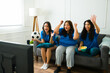 © AntonioDiaz - Attractive young women enjoying watching sports on tv