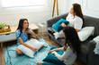 © AntonioDiaz - Hispanic female friends talking and relaxing in their pajamas