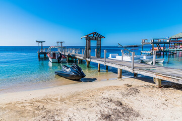 Wall Mural - A view of marine vessel beside a jetty in West Bay on Roatan Island on a sunny day