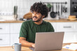© kucherav - Successful Indian man programmer, IT specialist or digital developer freelancer with laptop works remotely from home, looking away