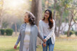© itchaznong - Adult daughter holding her elderly mother hand with love and walk together