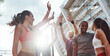 © gstockstudio - Group of happy young people in sports clothing giving high five while standing outdoors together