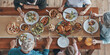 © gstockstudio - Top view of multi-generation family having dinner while sitting at the big table together
