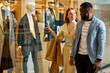 © Roman - elegant happy diverse couple takes pleasure in window shopping. close up side view photo