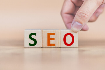 Wall Mural - search engine optimization concept man's hand is building a cube wood to search for information on the Internet online that can find information conveniently, quickly, easy to use in daily life