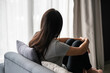 © Pattarisara - Stressed young Asian woman suffering on depression. Lady sitting alone on sofa in living room at home. Sad, unhappy, disappointed concept. Close up, Copy space