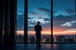 © Mountains Hunter - A businessman in a suit stands at panoramic windows, looks at the city from skyscrapers, a view from the back, an unrecognizable face, AI generative.