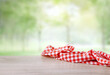 Red checkered cloth on wooden table empty space. Picnic towel natural background food display.