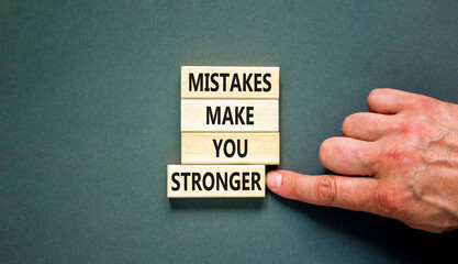 Wall Mural - Mistake make stronger symbol. Concept words Mistakes make you stronger on wooden blocks. Beautiful grey table grey background. Businessman hand. Business mistake make stronger concept. Copy space.