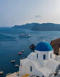 © Audrius - Panoramic view of Church of Agios Nikolaos in Oia town in Santorini. Traditional and famous white houses and churches with blue domes in Aegean sea
