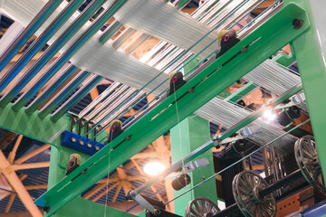 Leinwandbilder - synthetic textile thread,  thread at industrial weaving manufacturing machine,  textile fabric production industrial concept background