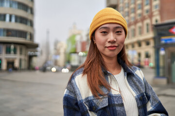 Joyful young Chinese woman thriving in the vibrant city.