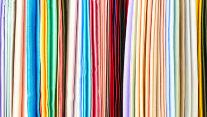 Poster - Mix colorful hanging vertical stripe textile, fabrics, cloths on the rack. Texture of multicolored fabrics close up.