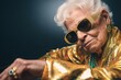 © Pajaros Volando - Cool grandma dressed with golden suit and sunglasses looking and posing to the camera. Generative AI