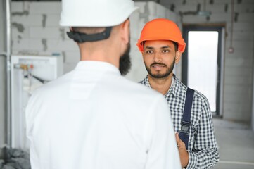 Wall Mural - Happy workers at construction site, young civil engineer manager and architects. Indian and Arabian engineers.