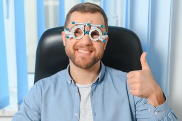 Wall Mural - Handsome young man is checking the eye vision in modern ophthalmology clinic. Patient in ophthalmology clinic