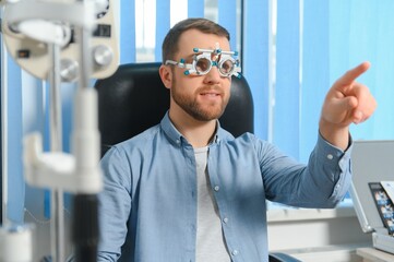 Wall Mural - Ophthalmology concept. Male patient under eye vision examination in eyesight ophthalmological correction clinic