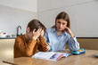 © DimaBerlin - Upset stressed child boy feeling frustrated while doing homework with mom at home. Kid sitting at kitchen table with teacher tutor having difficulties in learning. Problems with homeschooling