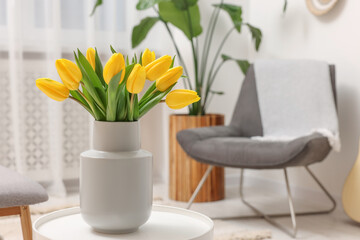 Sticker - Spring interior. Bouquet of beautiful yellow tulips on white table in living room, space for text