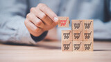 Fototapeta Mapy - Wooden block in businessman hand ,shopping cart icon,Consumer society ,Shopping service on online web and offers home delivery ,online shopping or e-shopping ,Shop online with a smartphone app