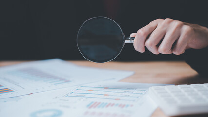 Aufkleber - Businessman holding a magnifying glass showing statistics bar graph inspection and analysis ,Analysis and improvement of corporate strategy ,Statistics and Data Concepts ,financial documents