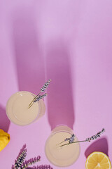 Wall Mural - Lavender lemonade in ribbed glasses and lemons on the purple background