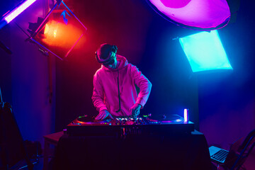 Male DJ playing music in the night club