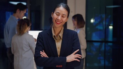 Wall Mural - Portrait of successful executive businesswoman smart casual wear looking at camera and smiling, happy in modern night office workplace. Young Asia lady standing relax in contemporary meeting room.